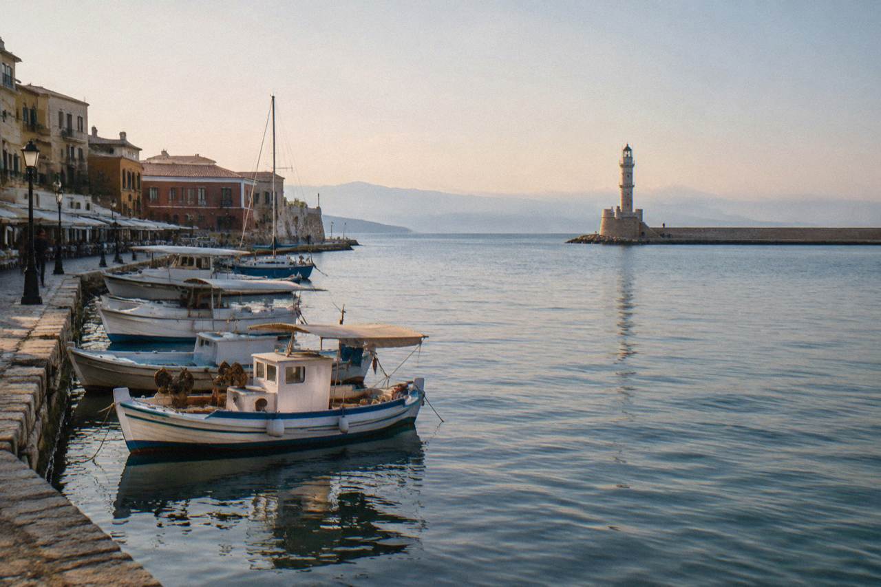 The Venetian Harbour of Chania with the lighthouse at the end of the mole and boats moored along the quay