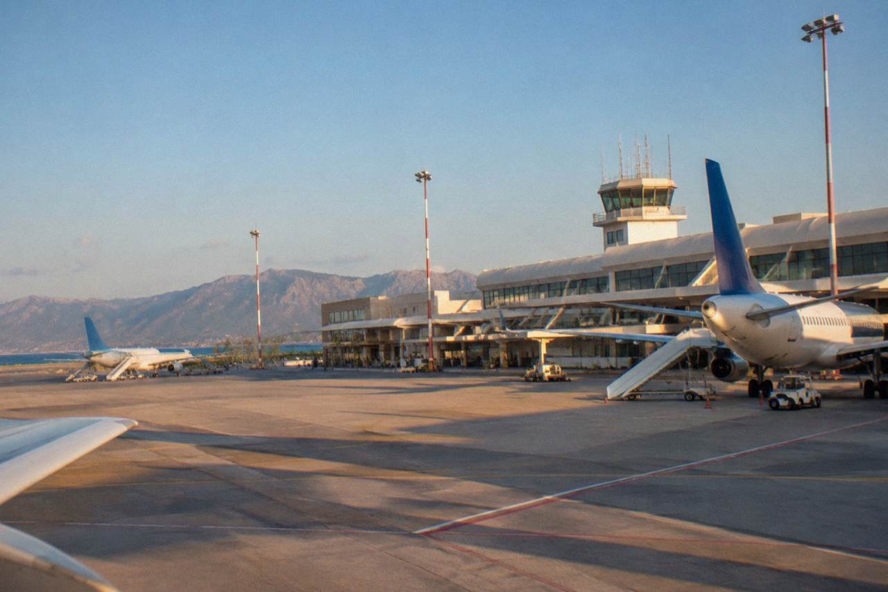The terminal building at Chania airport under a clear sky with parked aircraft on the apron