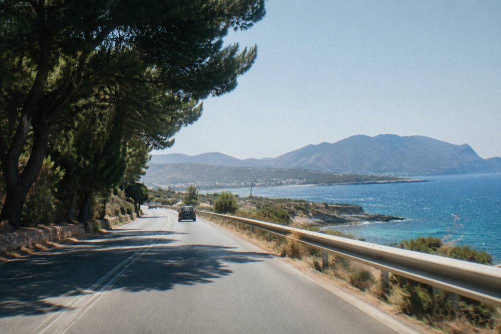 A road on the Akrotiri peninsula with sea and hills in the distance on the drive toward Chania