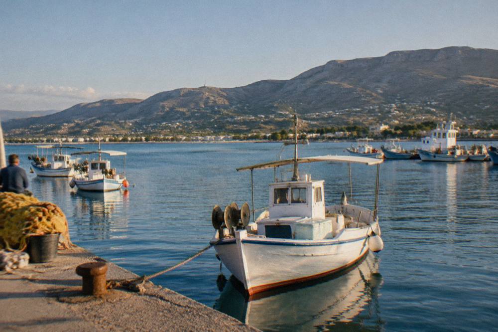 Fishing boats and quiet water in Souda Bay with hills rising behind the shoreline