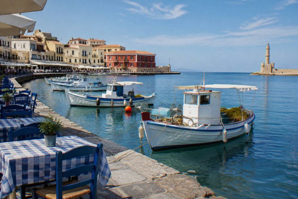 Fishing boats and waterfront tables along the Venetian Harbour in Chania Old Town
