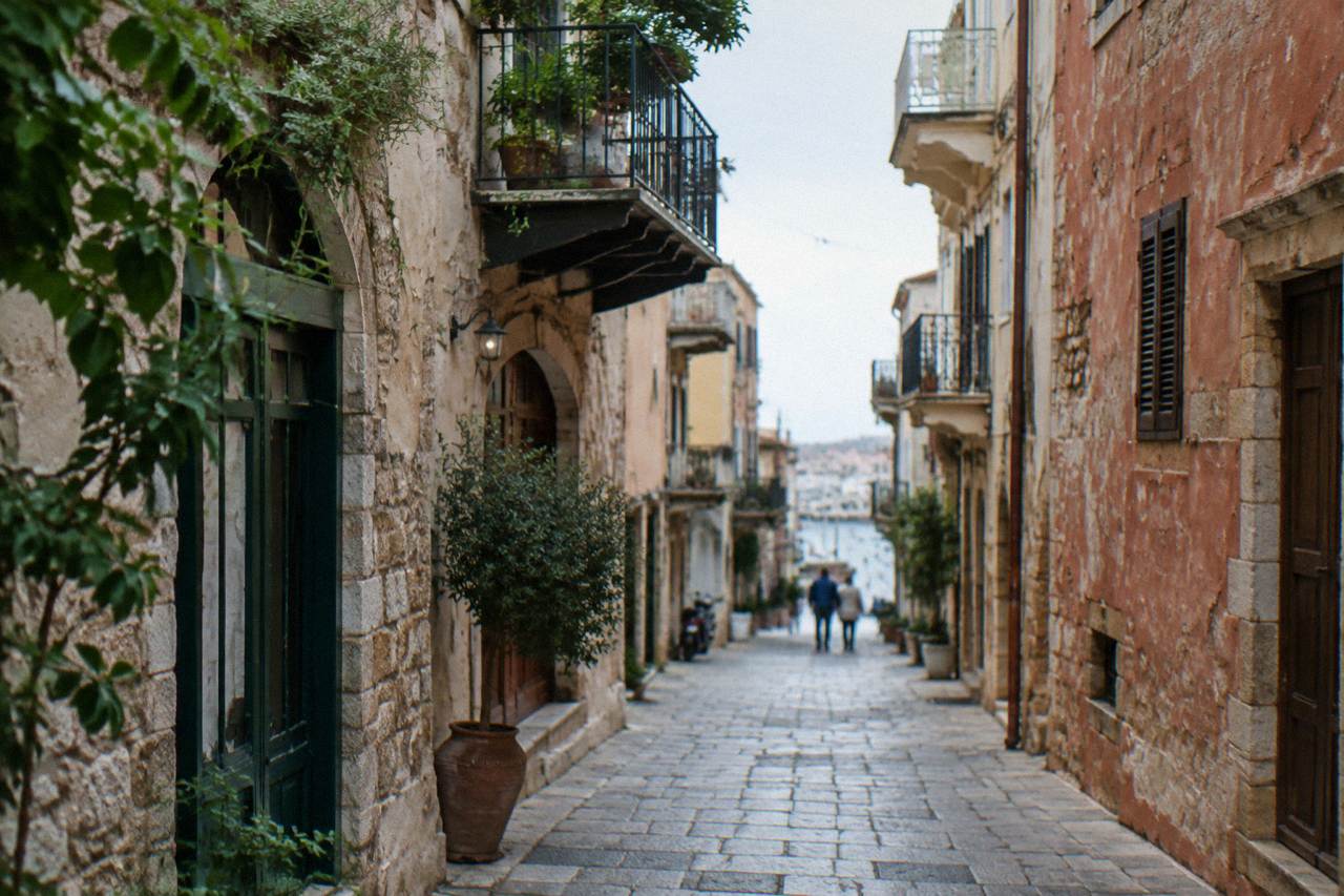 Narrow stone street with old buildings and balconies in Chania Old Town