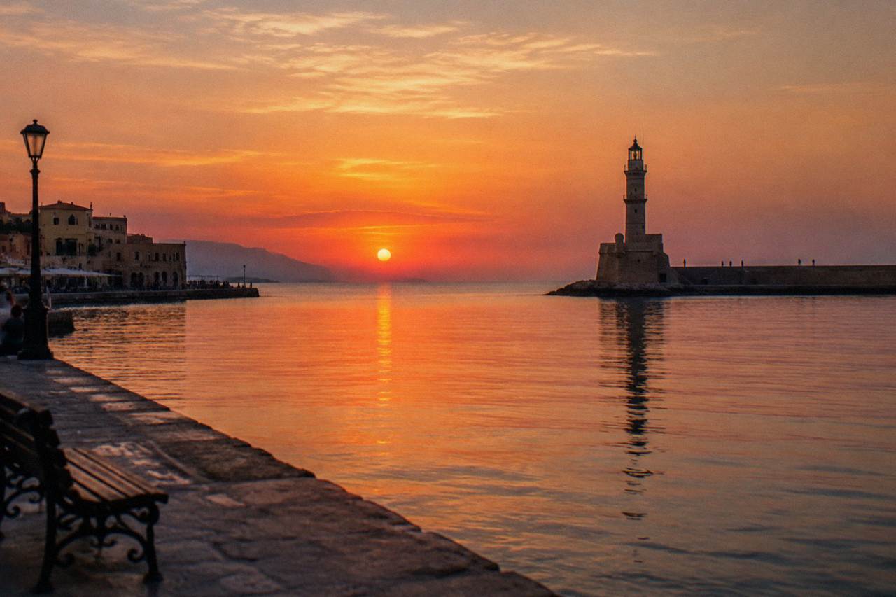 The Venetian Harbour of Chania at calm evening light with the lighthouse at the end of the breakwater