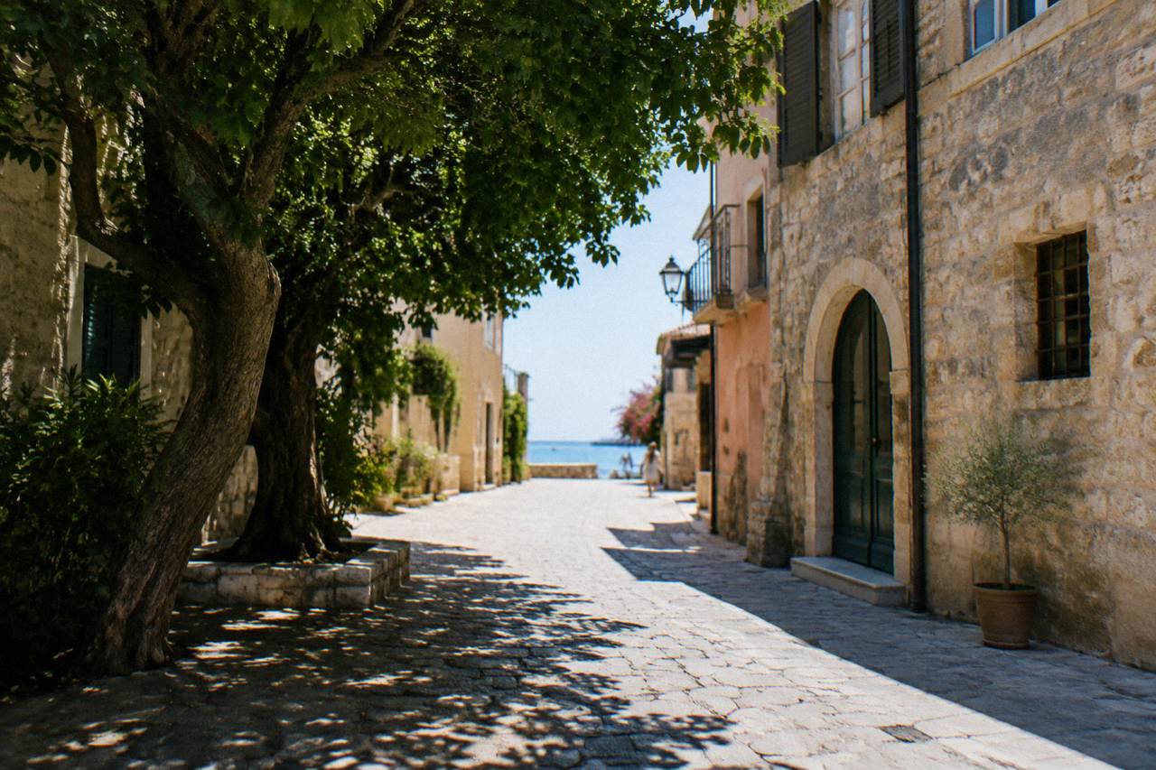 Quiet street of empty stone buildings under a strong midday sun on the island of Crete