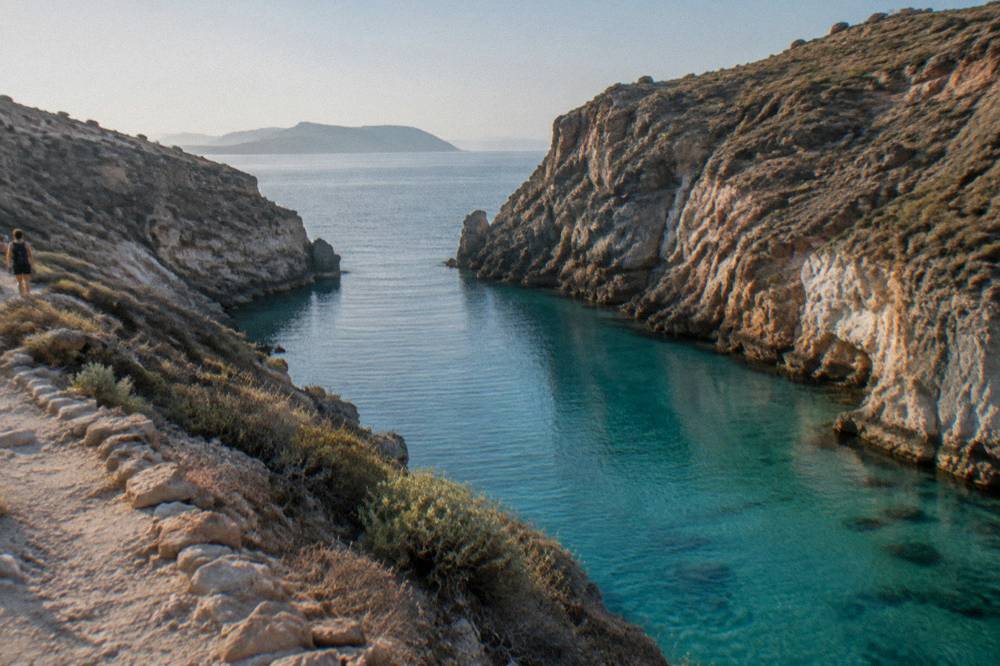 A narrow inlet of turquoise water between steep rock cliffs