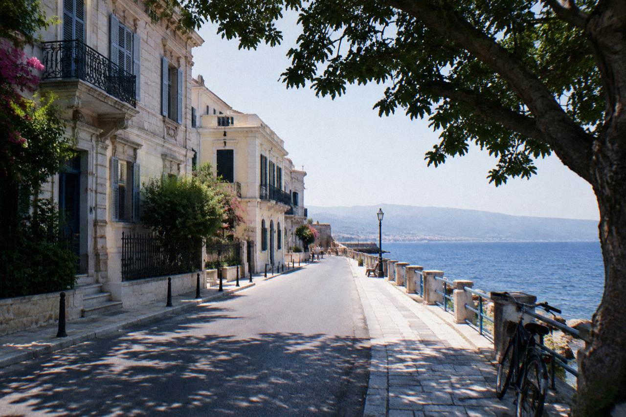 A quiet seafront street in Halepa with old mansions and the Cretan Sea beyond