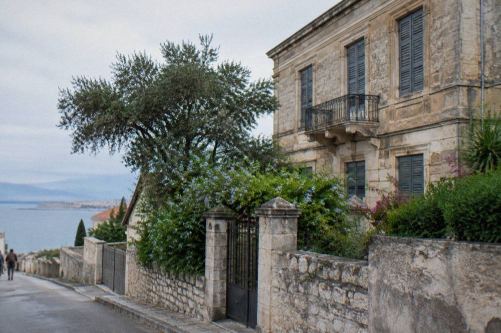 An old stone mansion in Halepa with a garden wall and shuttered windows