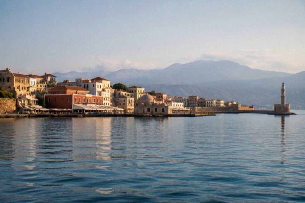 Wide view of the Venetian Harbour from the sea with the old town skyline and mountains behind