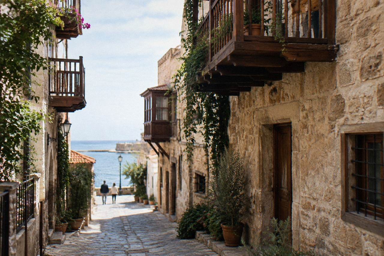 Narrow lane with stone walls and wooden balconies in Topanas, Chania