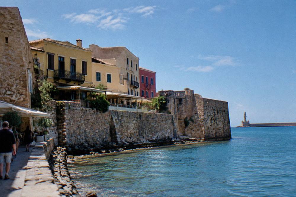 Old stone fortification wall with later buildings built against it in Chania