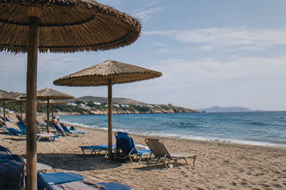 Beach umbrellas on sand under a clear blue summer sky