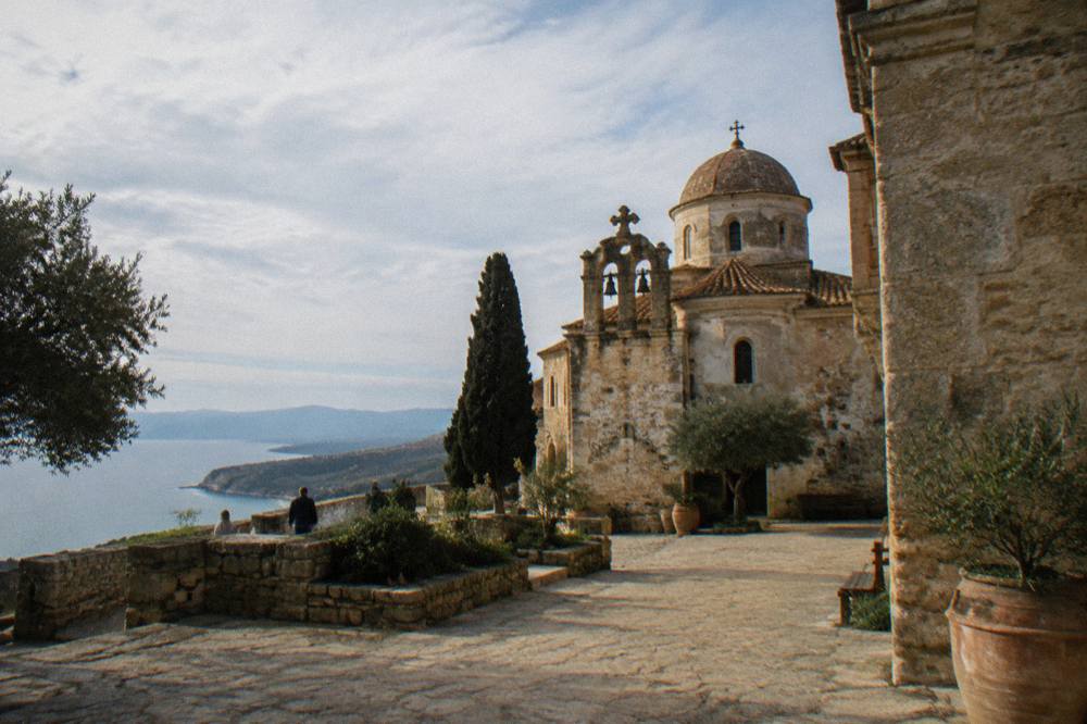 Warm stone monastery walls and courtyard on the Akrotiri peninsula under thin high cloud