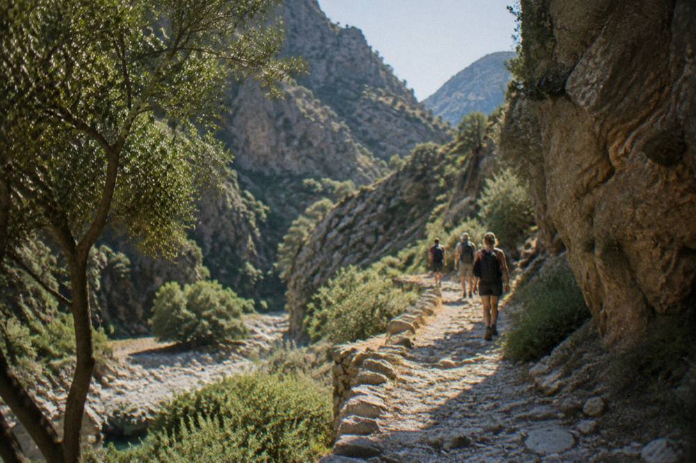 Hikers on a stony path inside a Cretan gorge