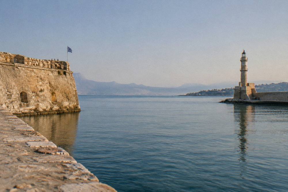 Clear summer day over the harbour entrance with calm water between the fortress and the lighthouse