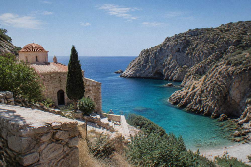 A turquoise cove framed by steep rocky cliffs on the Akrotiri coast
