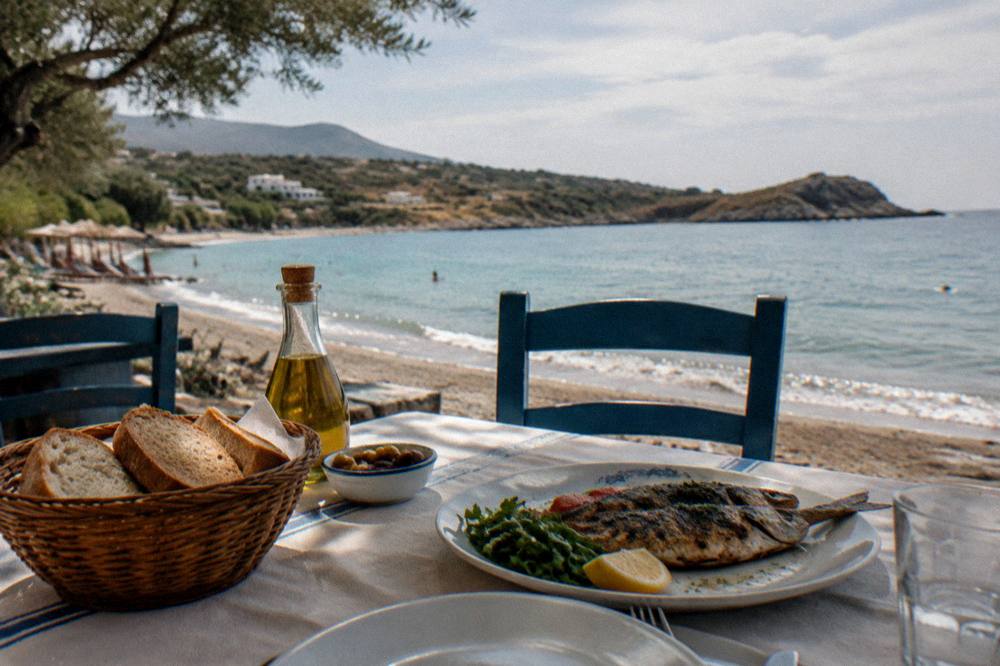 A simple Cretan taverna table with bread, olive oil and grilled fish near Kalathas Bay