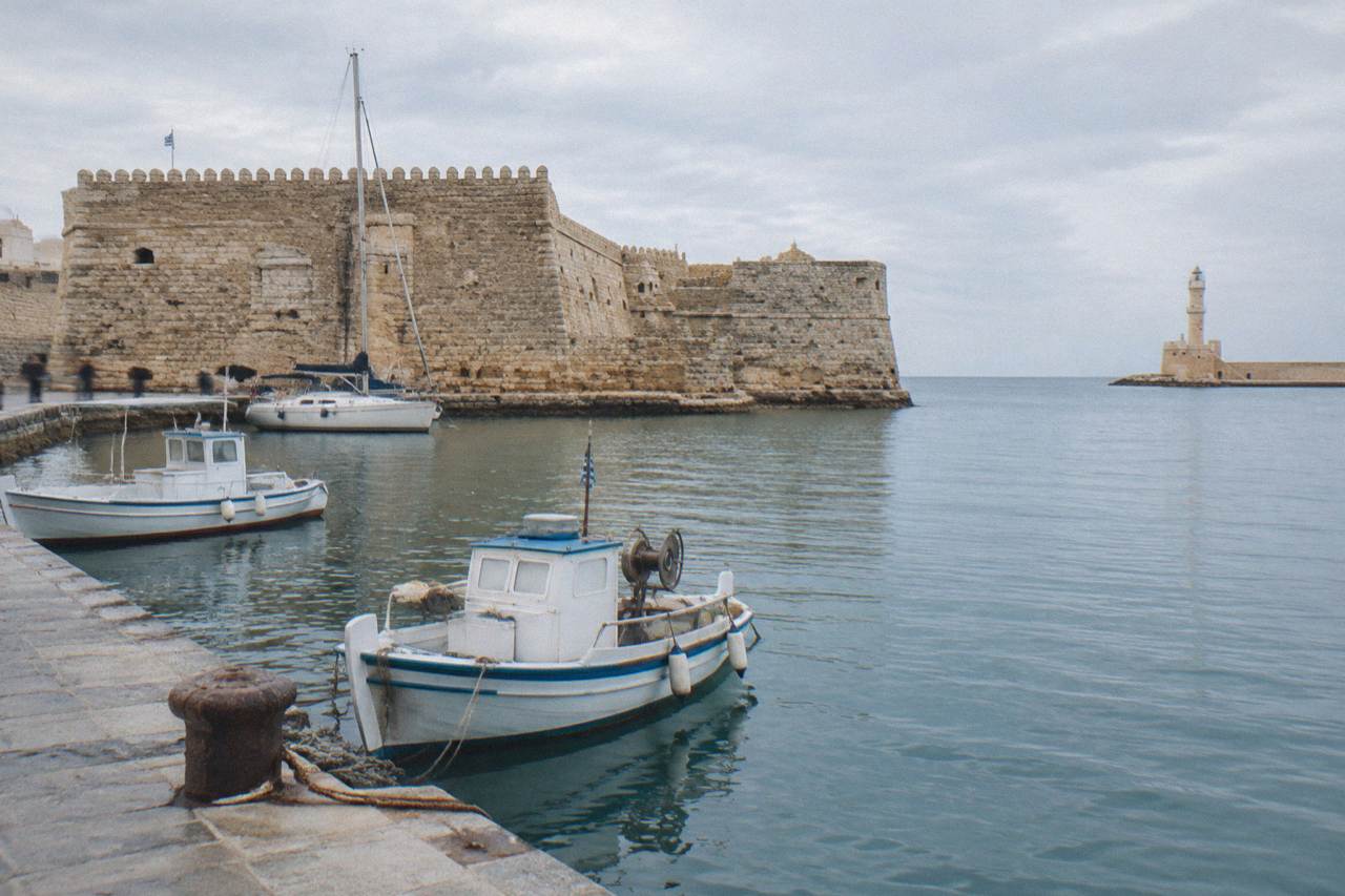 The stone walls of Firka Fortress at the western entrance of Chania harbour with boats on the water