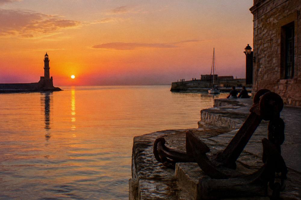 The harbour entrance channel at sunset with the lighthouse silhouette on the left
