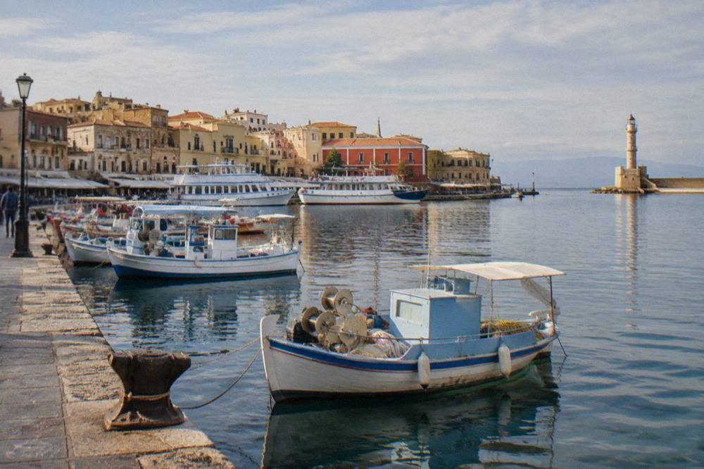 Fishing boats and excursion vessels moored along the inner quay of the Venetian Harbour in the morning