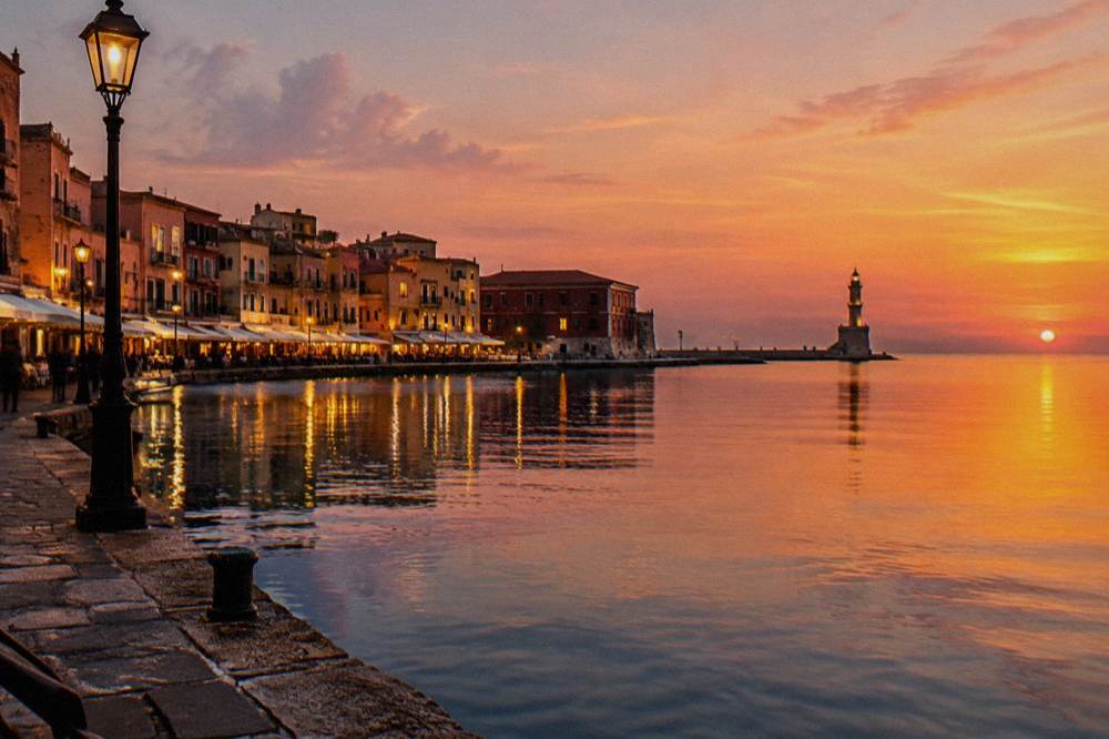 The Venetian Harbour waterfront at dusk with lit buildings reflected in the still water