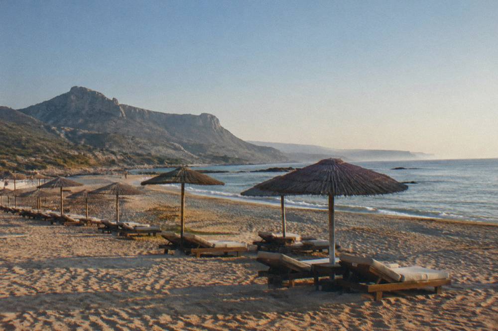 Empty beach umbrellas under a clear sky in early summer