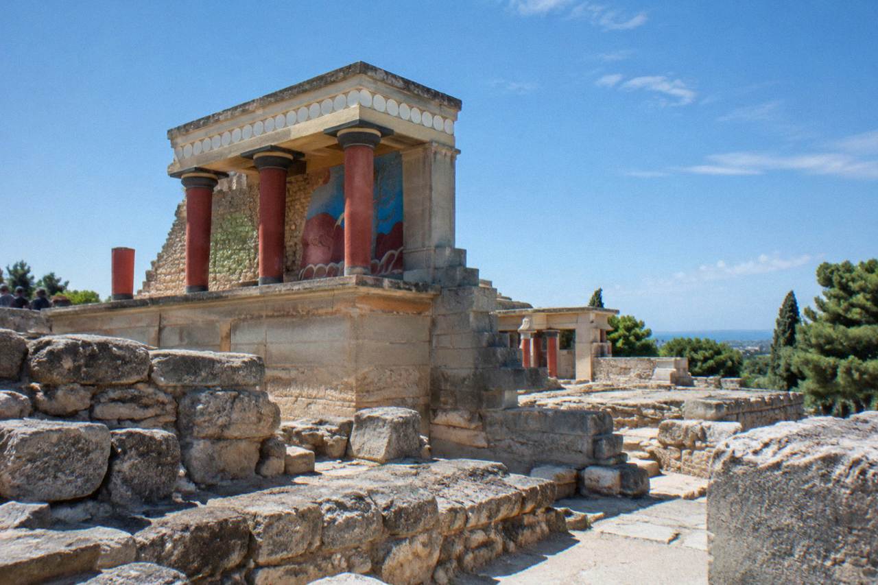 The stone ruins of an ancient palace complex standing under a clear sky near Heraklion