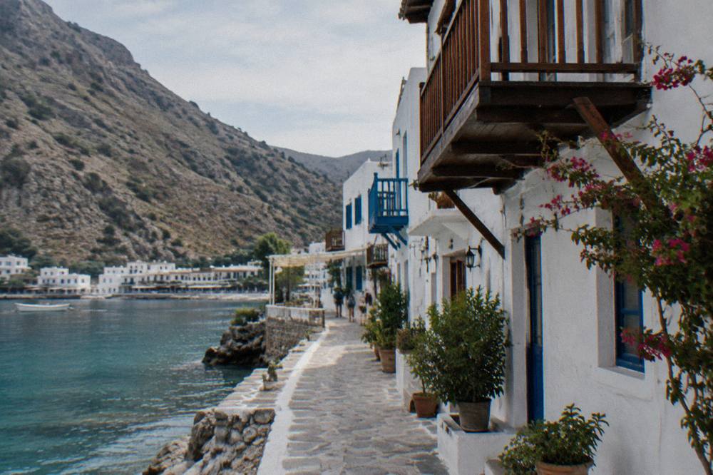 Whitewashed houses with wooden balconies along a narrow lane in a Cretan mountain village