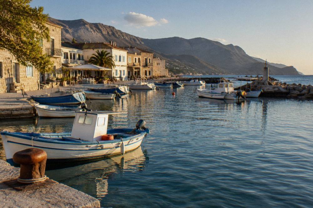 A quiet harbour on the south coast of Crete with small boats moored near stone buildings