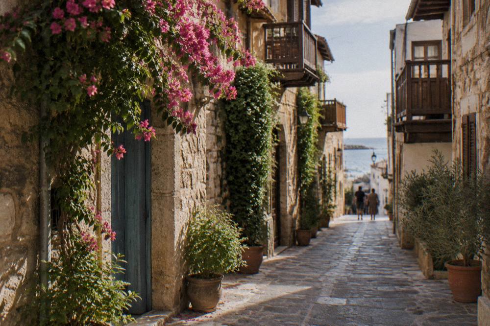 Narrow stone alley in Chania Old Town with cascading plants and wooden balconies