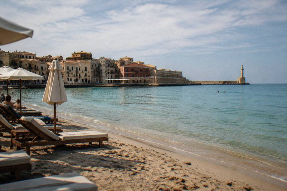 Sun loungers on a sandy beach near Chania with calm turquoise shallows