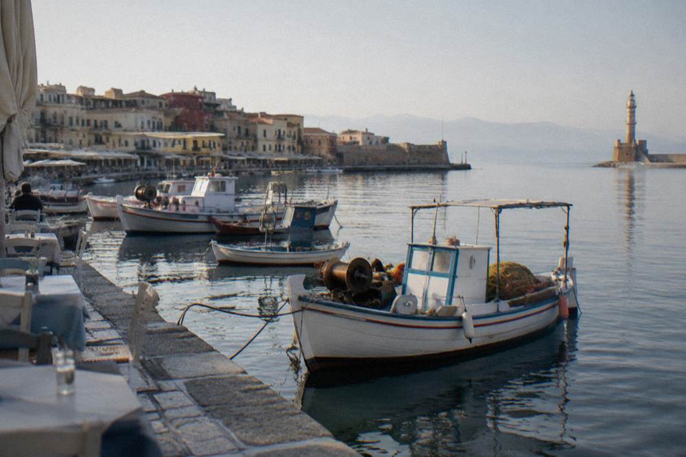 Fishing boats and waterfront tables along the Venetian Harbour in Chania