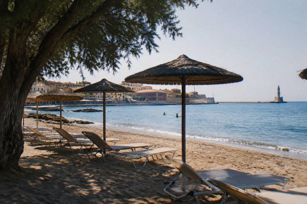 Empty sunloungers on a sandy beach near Chania in early morning light