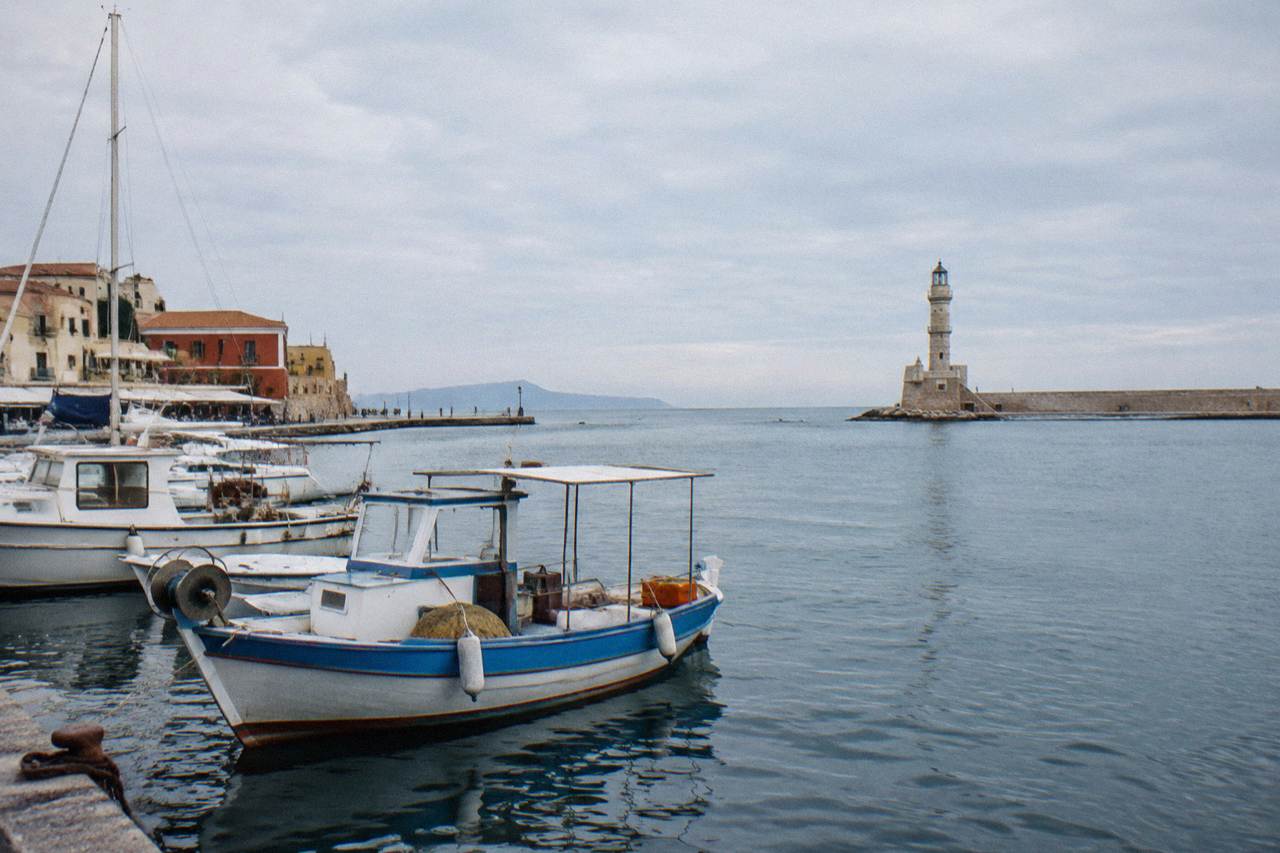 Boats moored in Chania Venetian Harbour with the lighthouse in the background