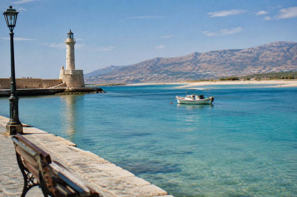 A shallow turquoise lagoon with a sandy spit and hills behind
