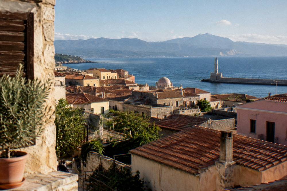 Morning view over tiled Old Town rooftops toward the sea and distant mountains