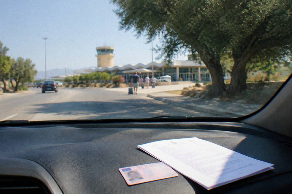 A driver's licence and a rental agreement on a car dashboard