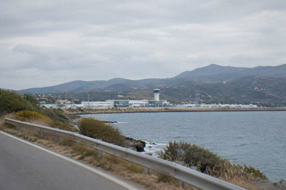 for Chania airport seen from a coast road with hills behind