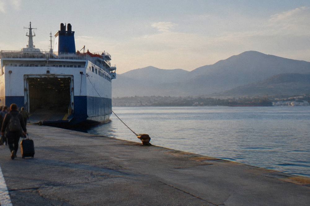 A ferry at a quayside in early morning light with hills in the background