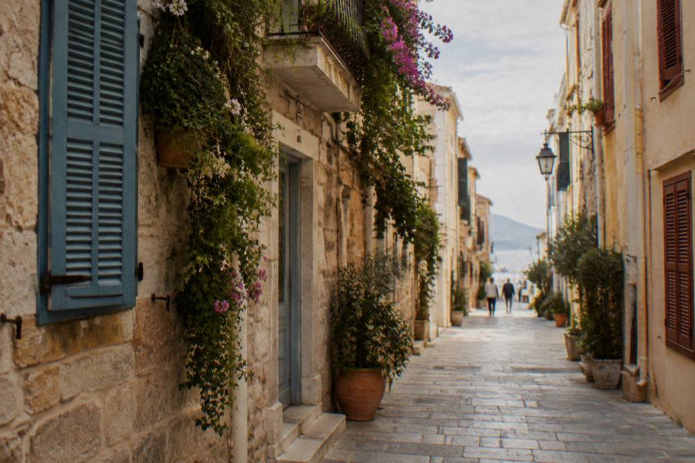 Narrow stone lanes of Chania Old Town with shuttered buildings and hanging plants in the morning