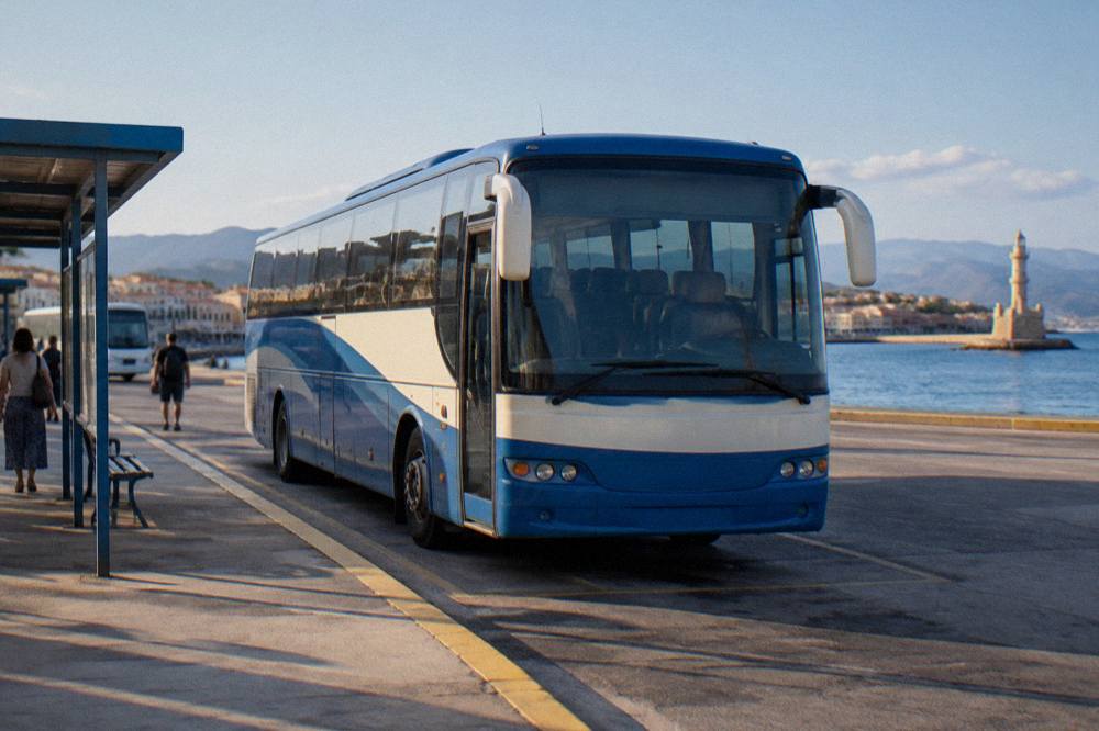 Blue and white KTEL bus at a station stop in Chania under bright light