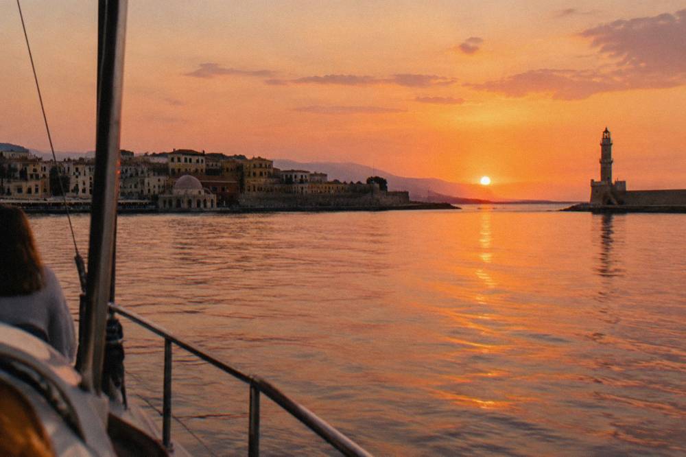 A calm sea at sunset seen from a boat off the Chania coastline