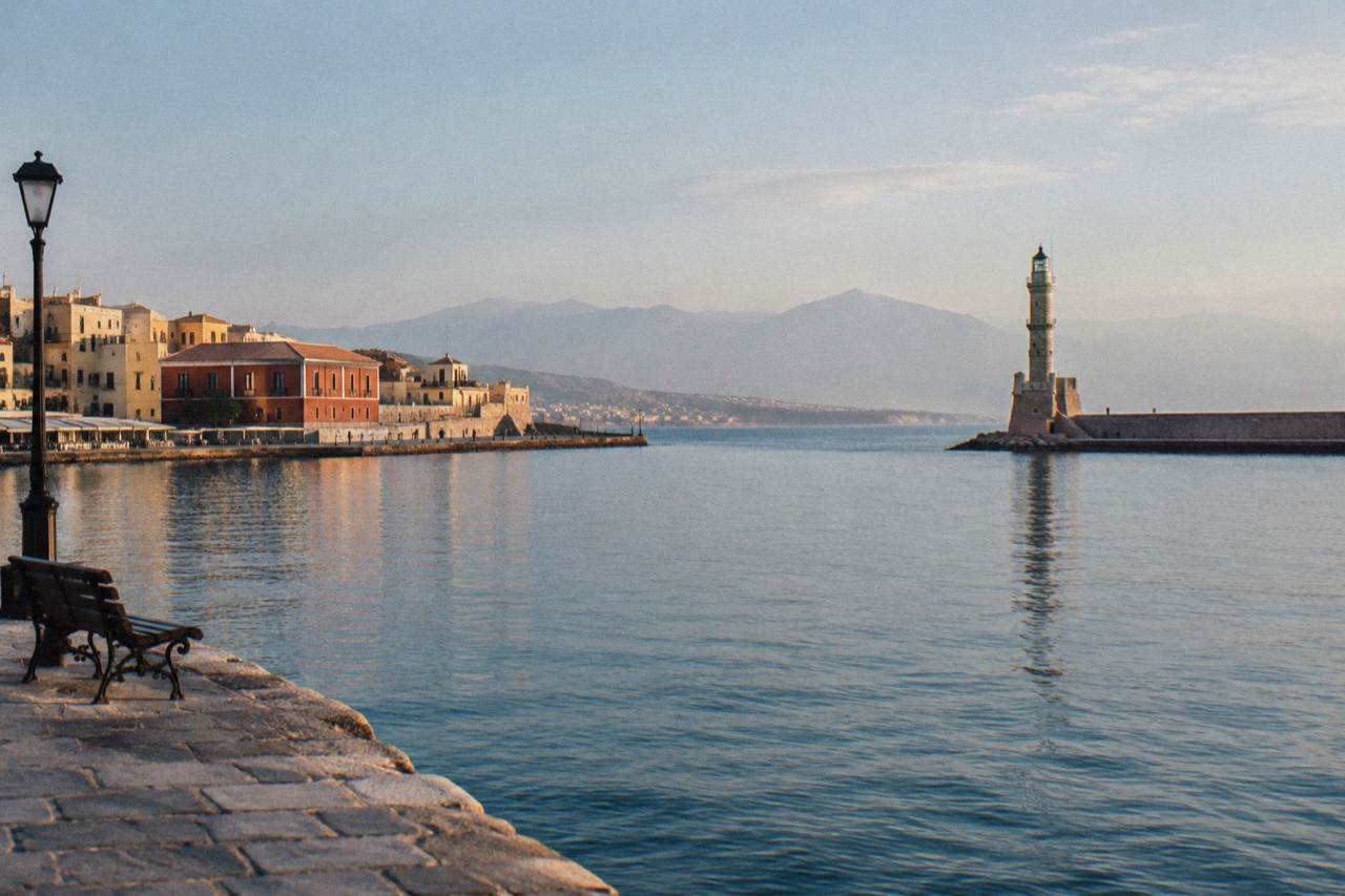 The Venetian Harbour of Chania under a calm winter sky with the lighthouse at the end of the mole