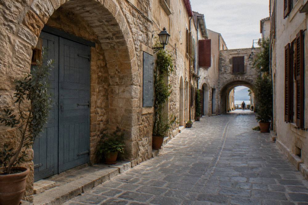 Empty cobblestone alley in the Old Town of Chania with stone archways and closed shutters