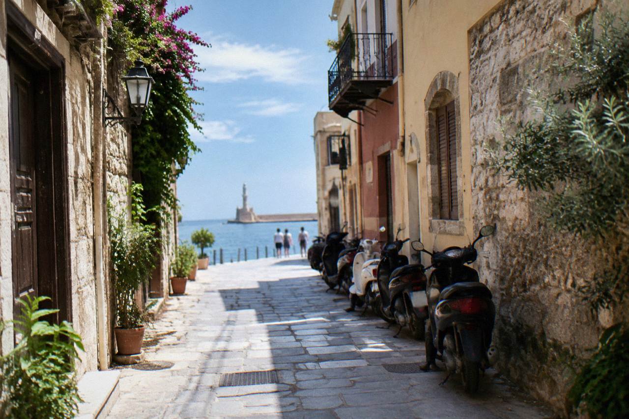 Narrow stone street in Chania Old Town with parked scooters along one side