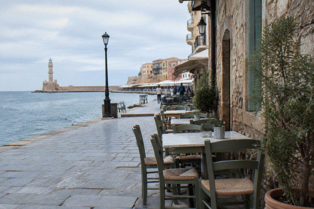 Tables set beside old stone buildings on a narrow street in Chania Old Town