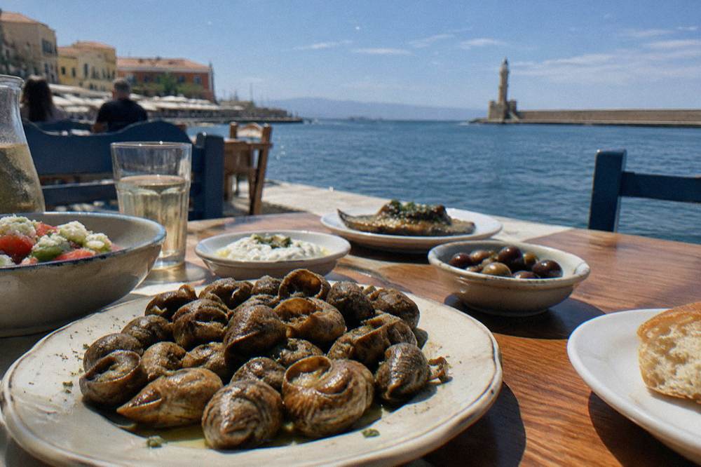 Fried snails and small dishes served on a wooden table in a taverna