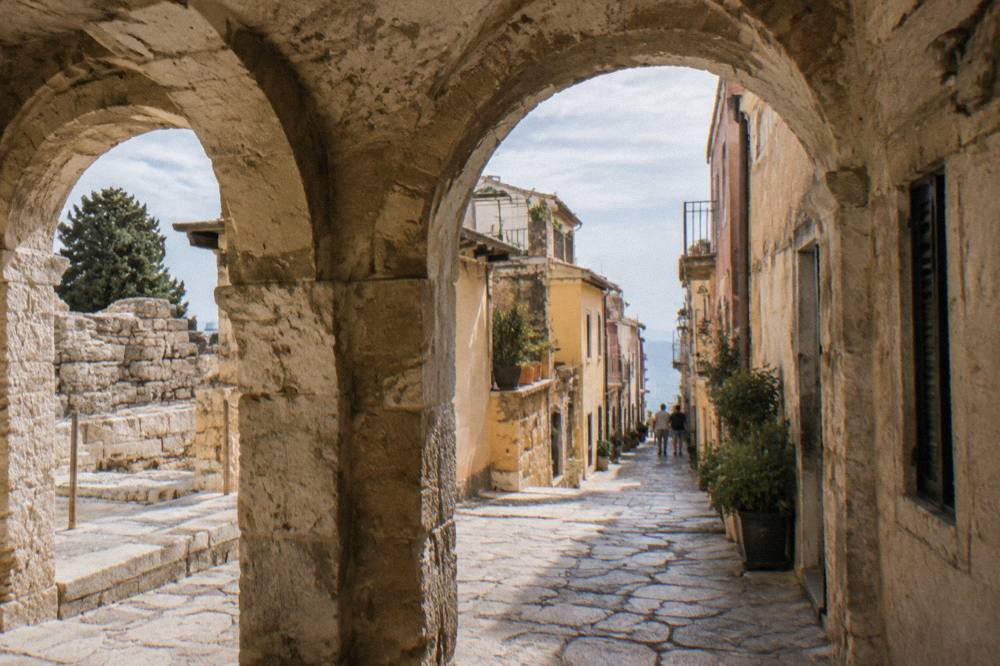 A stone arcade opening onto a narrow lane of old buildings in Chania Old Town