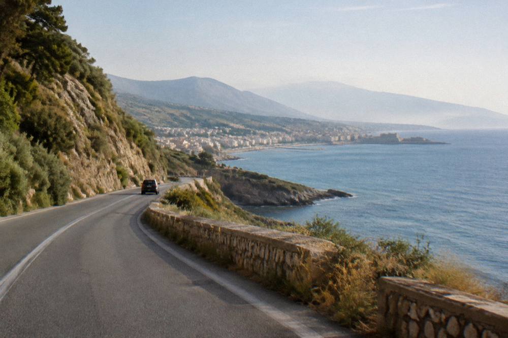 A coastal road winding between hills and the sea on the north coast of Crete
