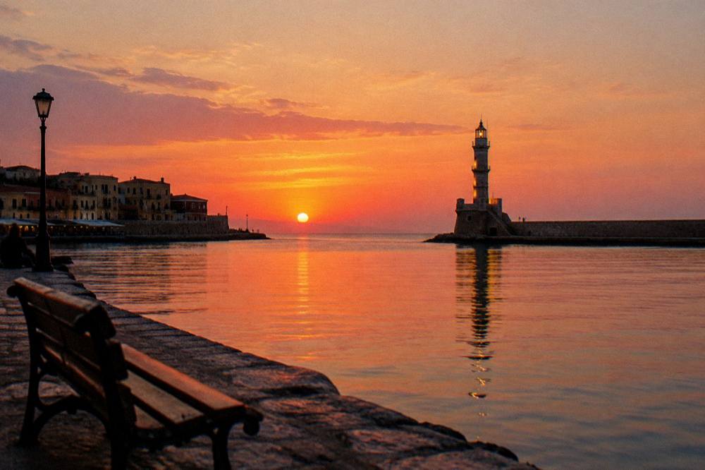The Venetian Harbour of Chania at dusk with the lighthouse lit at the end of the mole