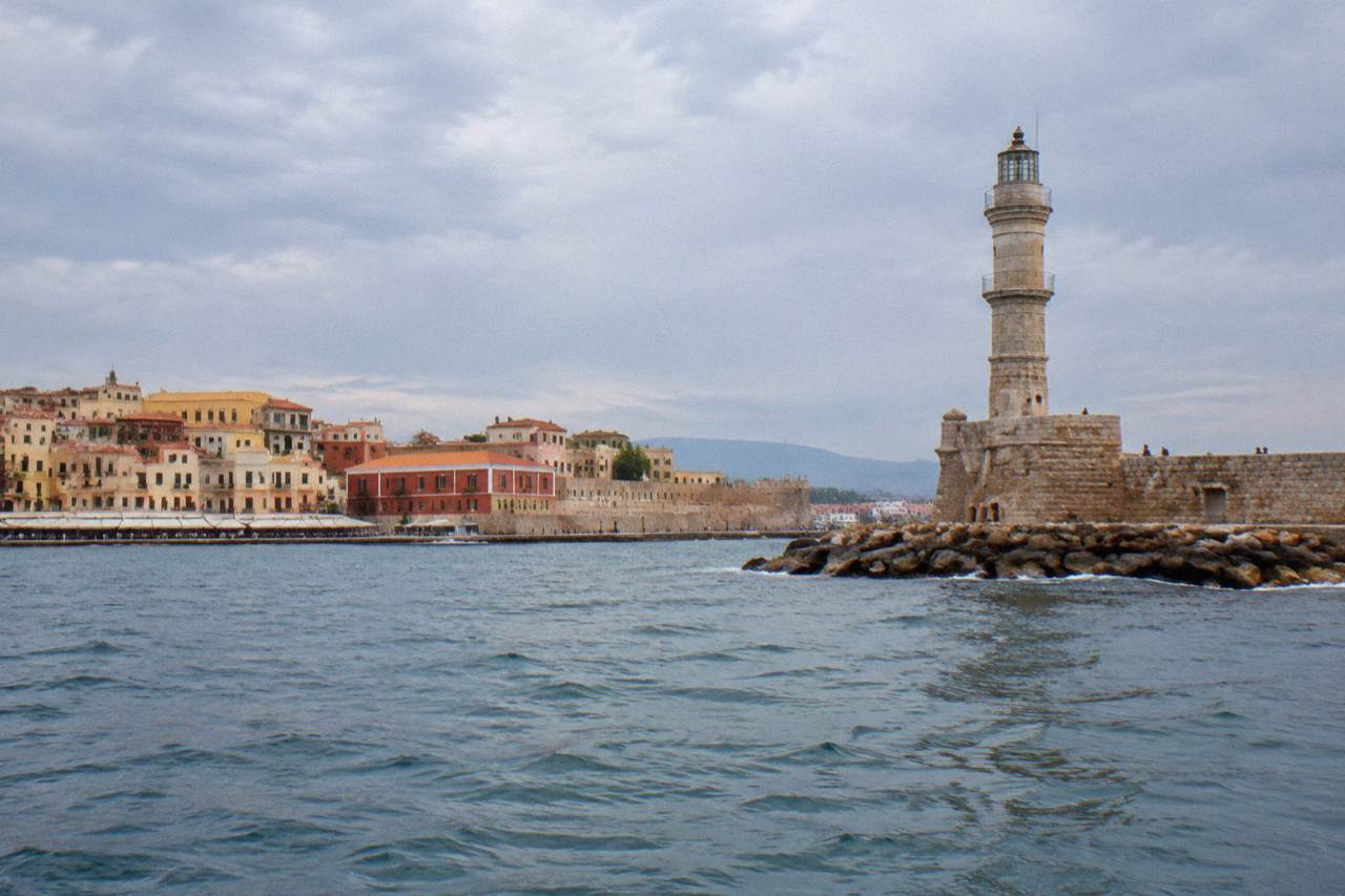 The Venetian Harbour of Chania seen from the water, with the lighthouse on the mole and buildings along the quay